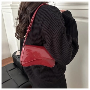 Details der roten Lackleder-Achseltasche mit dekorativem Knotendesign am Schultergurt