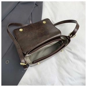 Detail view of the deep brown vintage handbag interior with zippers and magnetic buckles