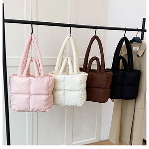 Detalle de cuatro bolsos tote acolchados de plumón en colores rosa, beige, marrón y negro