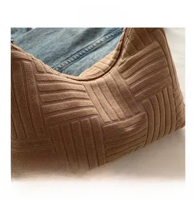 Detailed close-up of camel brown tote bag featuring textured 3D knit grid patterns