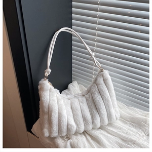 Détail du sac à main en fausse fourrure blanche avec texture rayée et bandoulière nouée