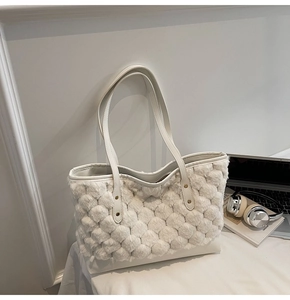 Detalle de textura de felpa de burbujas y base de cuero en un bolso tipo cubo beige
