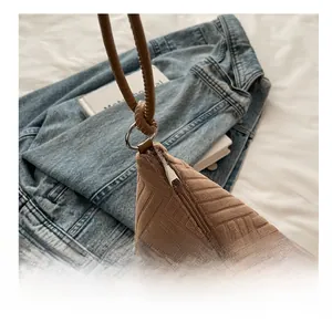 Detail view of smooth metal zipper and brown cylindrical handle on vintage tote bag