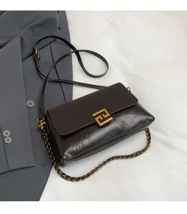 Detail der dunkelbraunen Lederhandtasche mit goldenem F-Verschluss und Kettenriemen