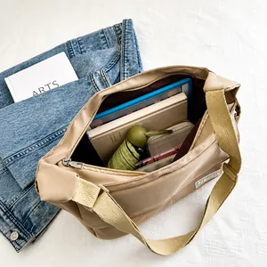 Vista interna della borsa a tracolla in nylon kaki che mostra la capienza per tablet e altro