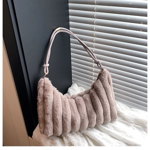 Détail d'un sac en peluche violet clair avec texture ondulée et accents de lanière