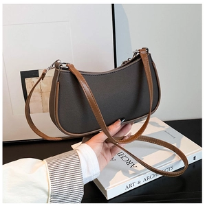Detalle de bolso de lona gris con correas de cuero marrón y herrajes plateados vintage