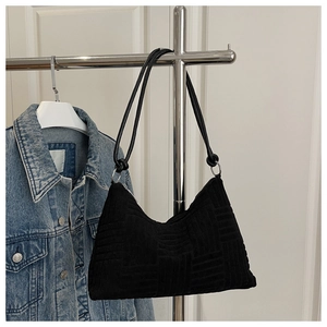 Detail showing woven texture and silver metal rings on a black shoulder tote bag