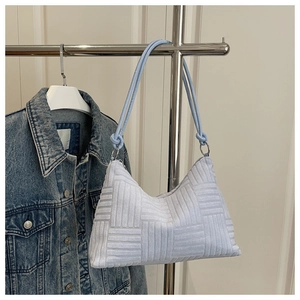 Detail of light blue hobo bag showing square woven texture and rope shoulder strap