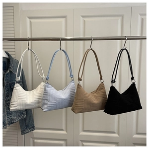 Detailed view of four shoulder bags in white, blue, brown, and black with geometric texture