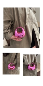 Detail of mini metallic pink crossbody bag with gold chain and openwork semicircular design