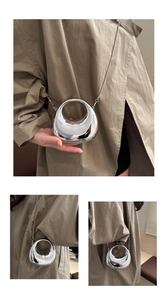 Detail of the high-gloss silver mini bag featuring a circular handle and chic metal chain