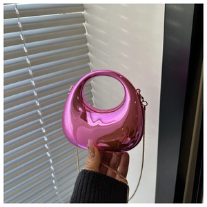 Close-up of metallic pink crescent bag with acrylic chain and polished mirror finish