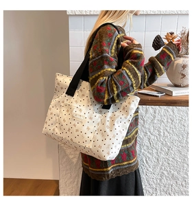 Détail du sac fourre-tout en velours blanc avec fleurs marron et étiquette mode
