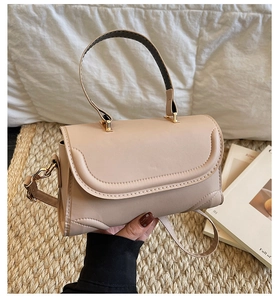 Detail der beige Handtasche mit goldenen Beschlägen und abnehmbarem Schultergurt