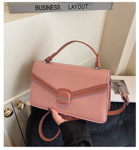 Détail d'un sac bandoulière rose avec texture en V et boucle en métal argenté