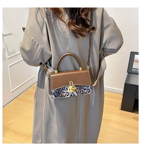 Sac bandoulière chic à imprimé léopard porté avec un manteau beige élégant