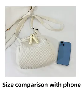 Detailed size comparison of the corduroy shell bag next to a smartphone