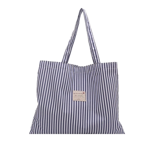 Minimalist blue and white striped canvas tote bag with long handles and a central fabric label