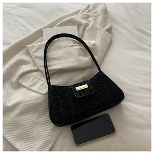 Detail der schwarzen Baguette-Tasche mit Leopardenmuster, Wildlederoptik und Goldverschluss
