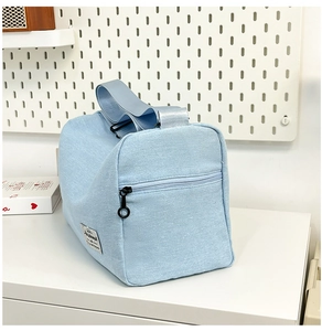Detalle del bolso de lona azul claro con cremallera duradera y correa ajustable