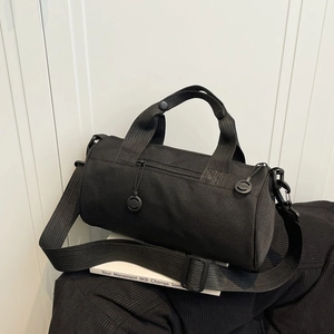Minimalist black cylinder duffel bag for gym and travel with adjustable shoulder strap