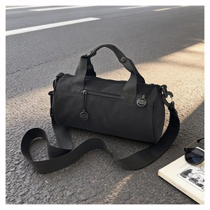 Detail of durable black nylon cylindrical gym bag with metallic hardware and branding