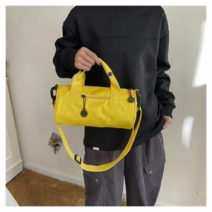 Detail of yellow cylinder sports bag with black zipper and adjustable shoulder strap