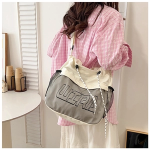 Detail of the oversized canvas messenger bag with mesh pockets and ULTRA lettering