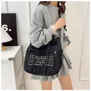 Detail of black crossbody bag featuring large white ULTRA print and mesh side pocket