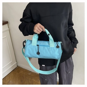 Detail of light blue cylinder sports bag showing texture and adjustable strap