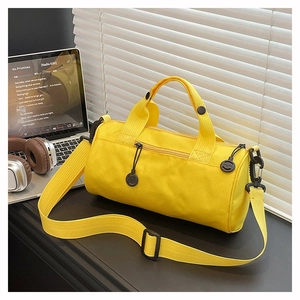 Detail of yellow cylinder sports duffel bag with zipper closure and nylon strap