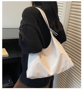 Side view of white minimalist leather tote bag showing large capacity and strap detail