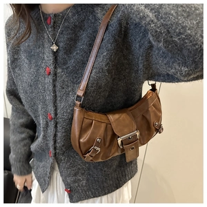 Brown pleated underarm bag with vintage metal buckle shown on model with casual outfit