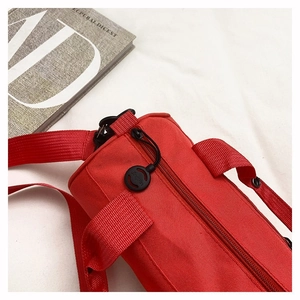 Close-up of red cylinder sports bag showing durable nylon texture and branded zipper puller