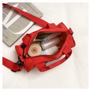Top view of red canvas duffle bag showing interior capacity with skincare bottles