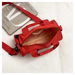 Interior detail of red cylindrical fitness bag showing lining and black zipper hook