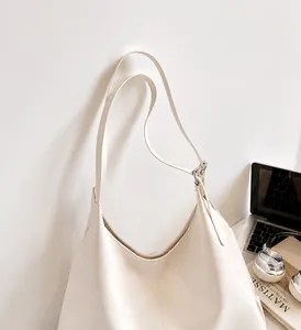 Detail view of cream oversized tote bag with sturdy double handles for daily commuting