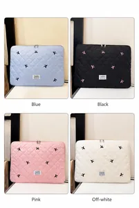 Quilted laptop sleeve featuring bow embroidery and fashion label in multiple colors