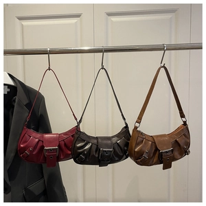 Detailed view of three pleated crescent underarm bags with vintage silver metal buckles