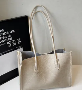 Detail of cream large tote bag showing soft leather texture and interior gray lining