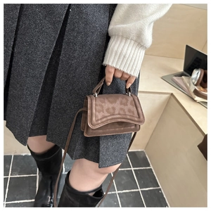 Detailed view of mini brown crossbody bag with leopard print flap and leather texture
