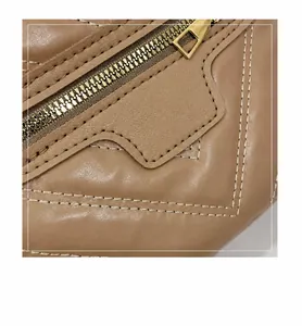 Macro-opname van bruine leren tas met metalen rits en hoogwaardige dubbele stiksels