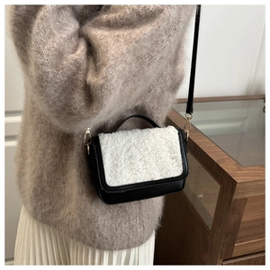 Detail of a vintage contrast flap bag featuring white faux shearling and black leather texture