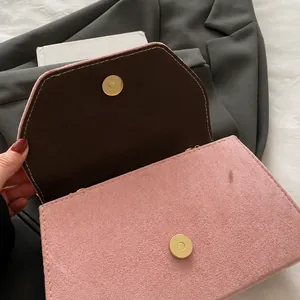 Detail showing pink suede texture and magnetic golden snap closure on stylish handbag