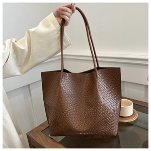Close-up of deep brown Intrecciato woven texture on a large capacity tote bag