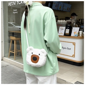 Detail of white plush bear crossbody bag showing soft texture and compact cartoon design