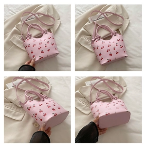 Detailed views of a pink tote bag featuring cherry prints and stylish knot handle design