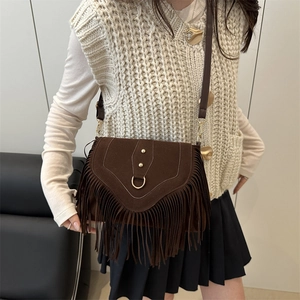 Brown suede bohemian fringe crossbody bag with gold D-ring and studs on model