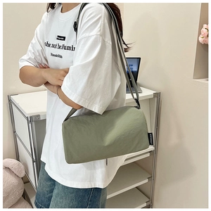 Detail of adjustable strap and sage green nylon fabric on minimalist crossbody bag